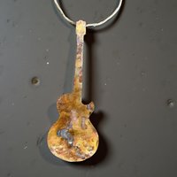 Copper electric guitar ornament on gray concrete background