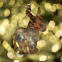 Copper donkey silhouette ornament, blurry twinkle lights background.