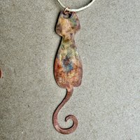 Copper skinny cat with curled tail ornament, on gray background 