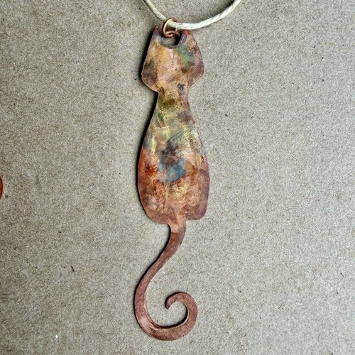 Copper skinny cat with curled tail ornament, on gray background 