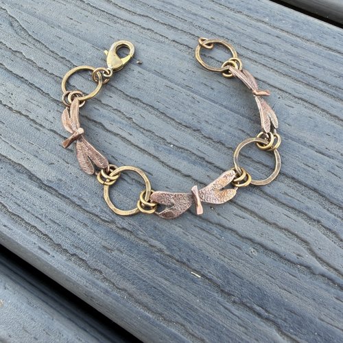 Three Dragonflies copper & bronze bracelet on flat surface, view 3