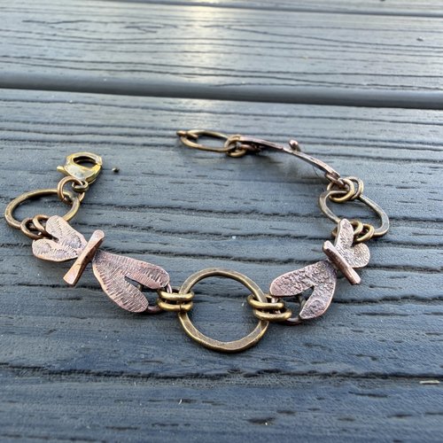 Three Dragonflies copper & bronze bracelet on flat surface, view 1