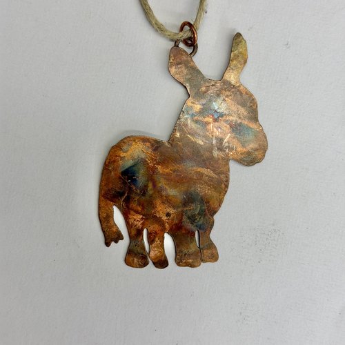 Copper donkey silhouette ornament, pale gray background.
