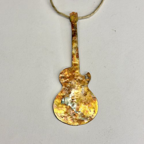 Copper electric guitar ornament on light gray background